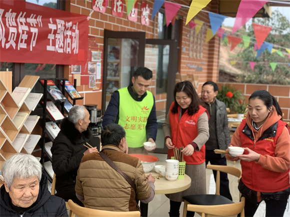 玉峰山村新时代文明实践站，志愿者邀请群众一起吃汤圆。王家街道办事处供图 华龙网发。
