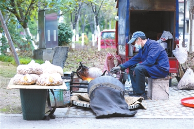 3梁山街道文峰社区，商贩在制作老式手摇爆米花。记者 熊伟 摄