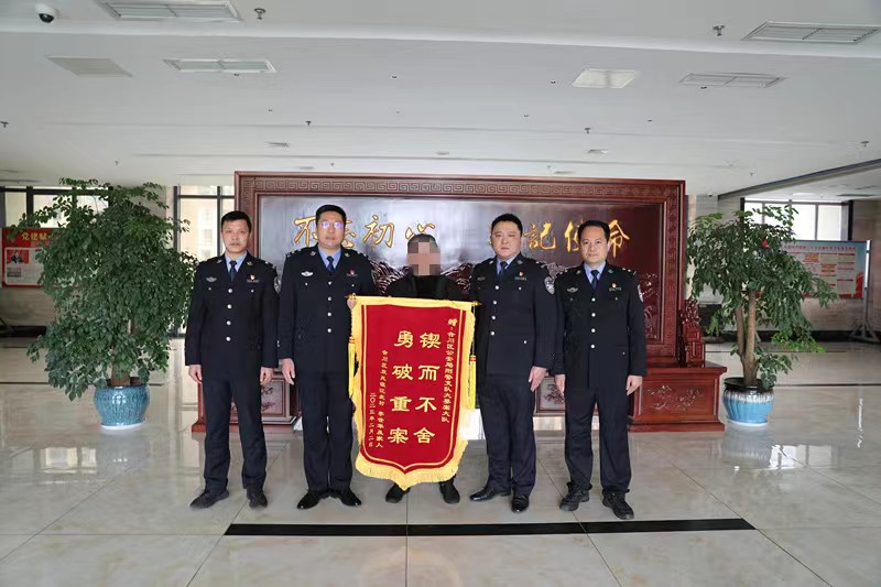 4被害人王武的哥哥王文向办案民警赠送锦旗，表示感谢。重庆市合川区警方供图