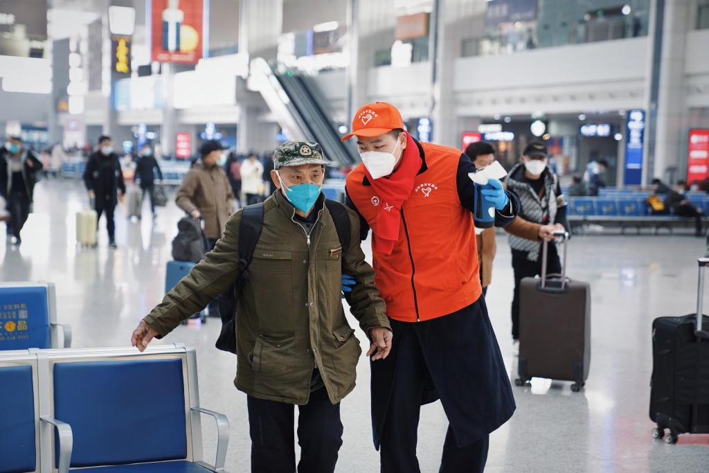 志愿者在车站协助旅客乘车。重庆火车站供图