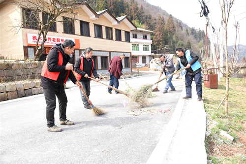 村组干部在打扫公路卫生。特约通讯员 隆太良 摄