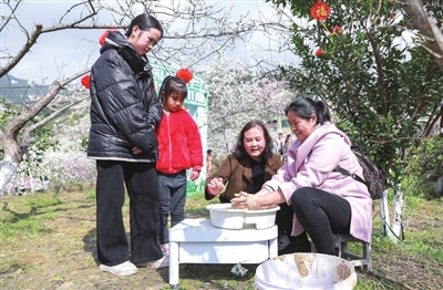 4合兴街道第八届李花节活动现场，游客在体验土陶制作。记者 熊伟 摄