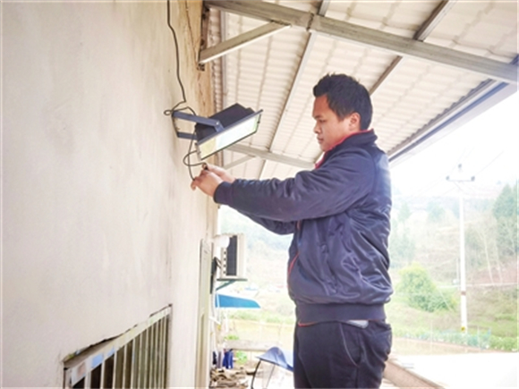 近日，石安镇龙坪村，工作人员在为村民安装太阳能院坝路灯。记者 高柔 摄