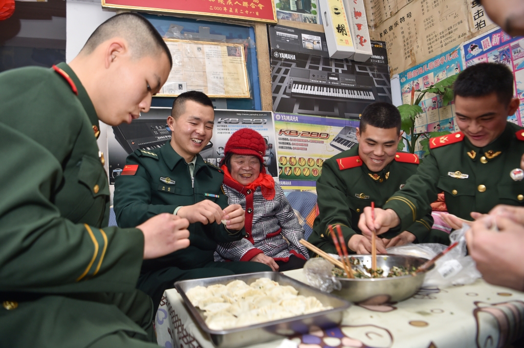 1中队官兵与刘玉珍在一起包饺子。通讯员 唐志勇摄