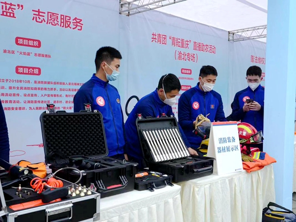“火焰蓝”志愿者服务队向居民展示消防装备器材。渝北区文明办供图 华龙网发
