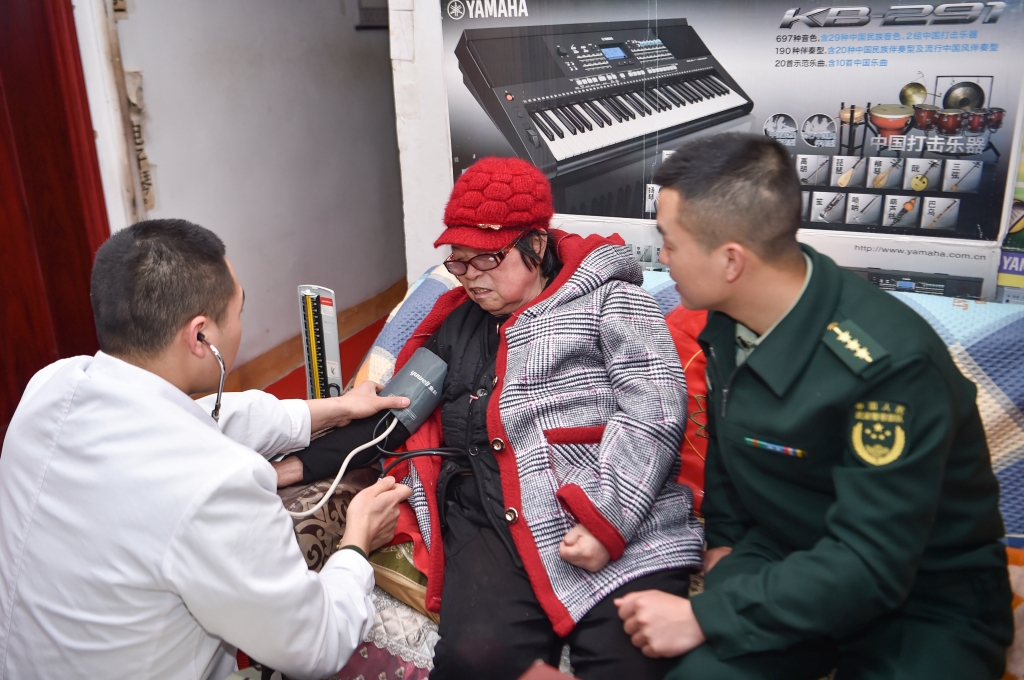 2卫生员给刘玉珍测量血压。通讯员 唐志勇摄 