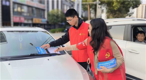 志愿者发放规范停车温馨提示宣传单。通讯员 魏潇 摄