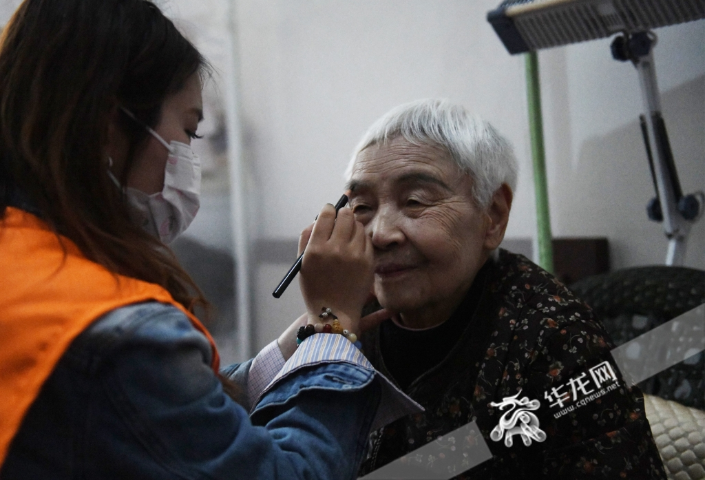 志愿者正在为老人们化妆。华龙网-新重庆客户端 记者 秦思思 摄