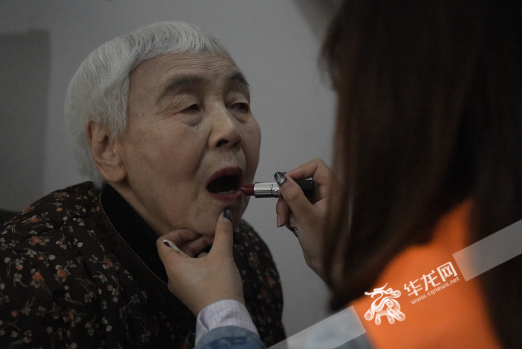 志愿者正在为老人化妆。华龙网-新重庆客户端 记者 秦思思 摄