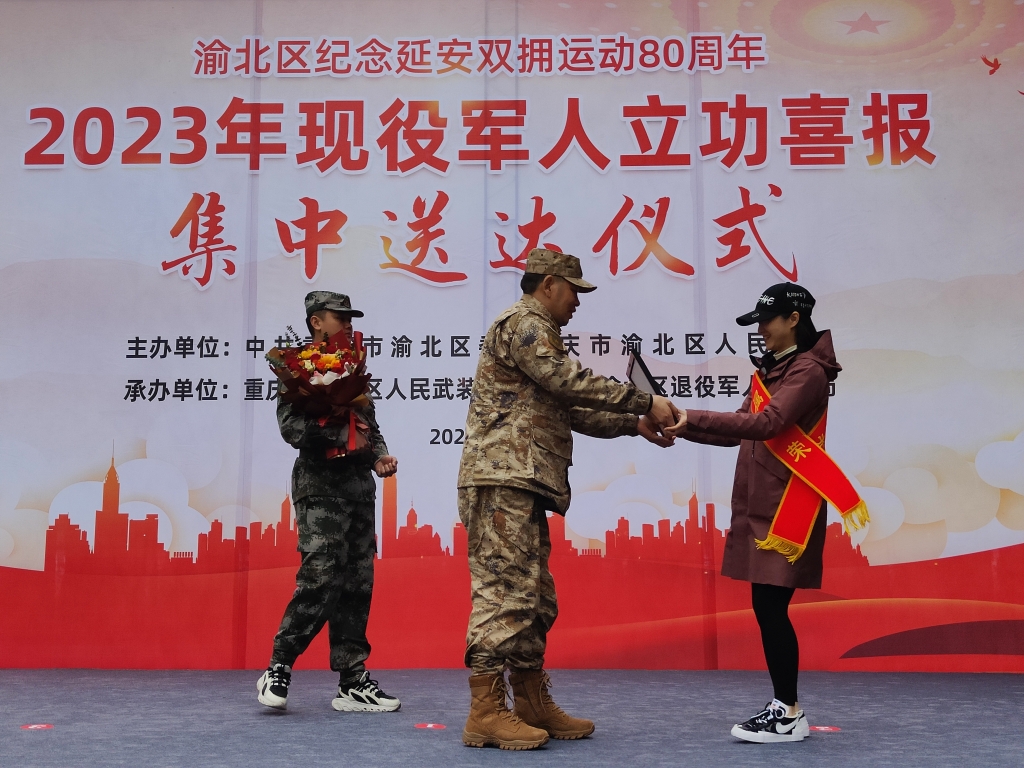 立功受奖现役军人的家属接过喜报。重庆市渝北区人武部供图