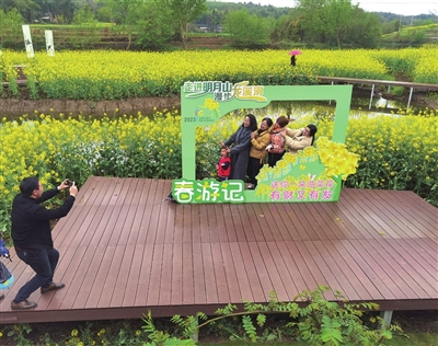 2023年龙溪河（荫平）首届“花漾赏花节”活动现场，游客在油菜花田拍照打卡。记者 郎兴花 摄