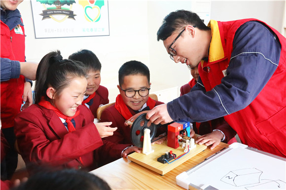2 志愿者和孩子们一起动手做手摇发电机点亮电灯泡实验，在游戏中科普发电原理、普及安全用电知识。通讯员 徐强 摄
