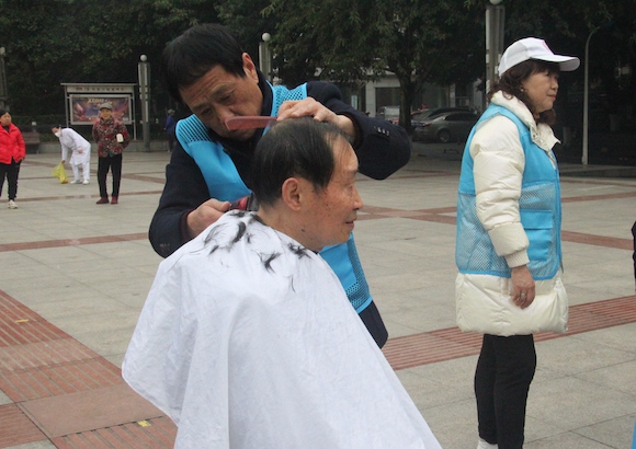 志愿者为居民义务剪发。江北区大石坝街道供图 华龙网发