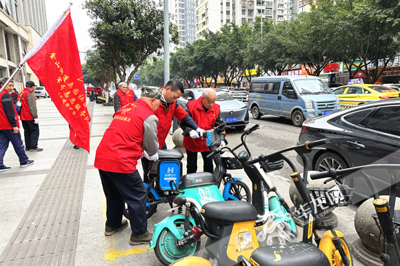 志愿者整理路面共享单车。华龙网-新重庆客户端 张颖绿荞 摄