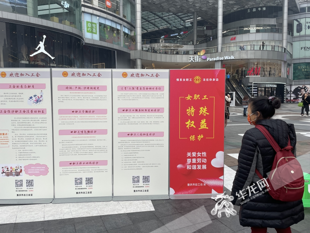 过路的市民观看现场展板中的女职工权益知识。华龙网-新重庆客户端 首席记者 王玮摄