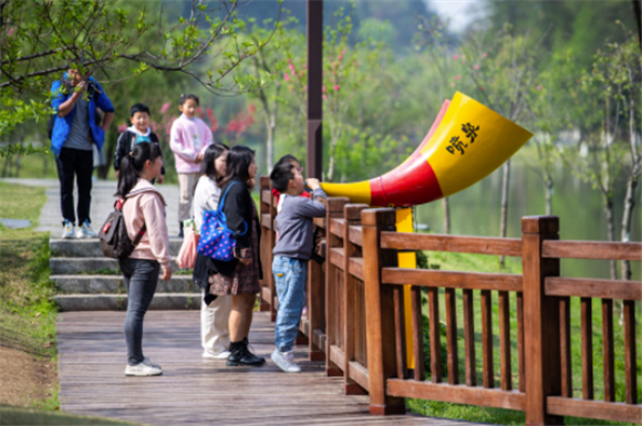 4月8日，游客在常德桃花源风景名胜区体验“喷泉”游戏。新华社记者 陈思汗 摄