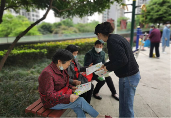 丹龙路社区工作人员为附近居民派发宣传手册。花园路街道供图 华龙网发