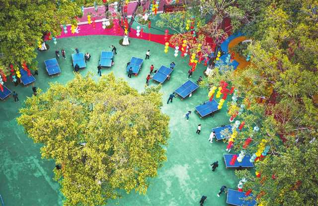 Many citizens are competing against each other at the table tennis table under the green trees at Dadukou Park. (Photographed by Zheng Yu / Visual Chongqing)