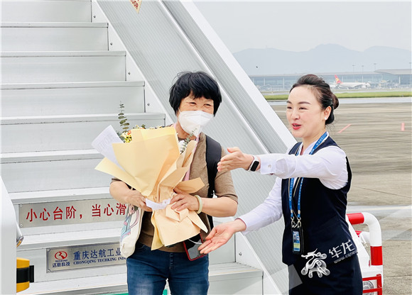 首批游客走下飞机。华龙网-新重庆客户端记者 曹建 摄