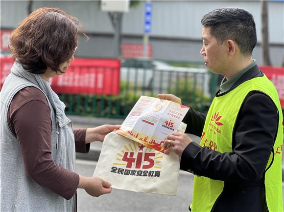 2社区志愿者正在向居民发放《国家安全法》宣传品。通讯员 陈天红 摄