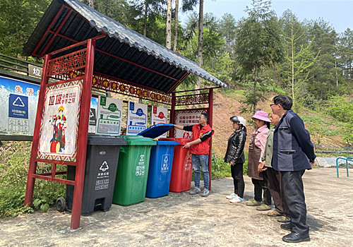 指导员在桶边为村民讲解垃圾分类知识。通讯员 张巧竹 摄