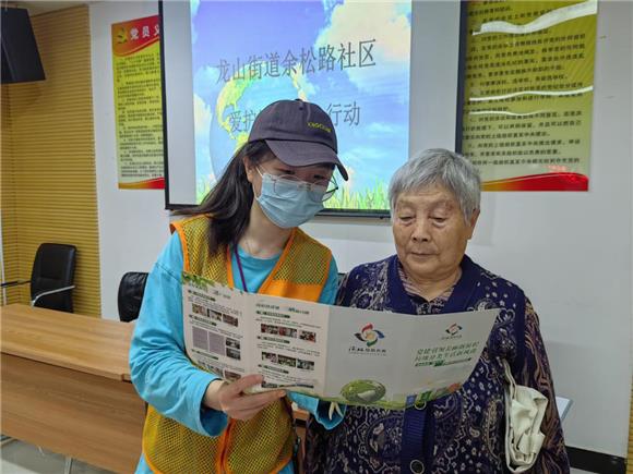 2志愿者向居民发放垃圾分类宣传手册。通讯员 徐诗颖 摄