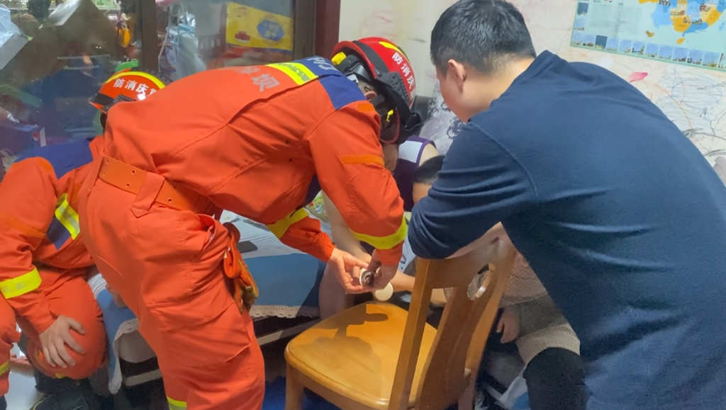 1消防员裁剪保温杯，帮助男孩脱困。重庆沙坪坝消防供图