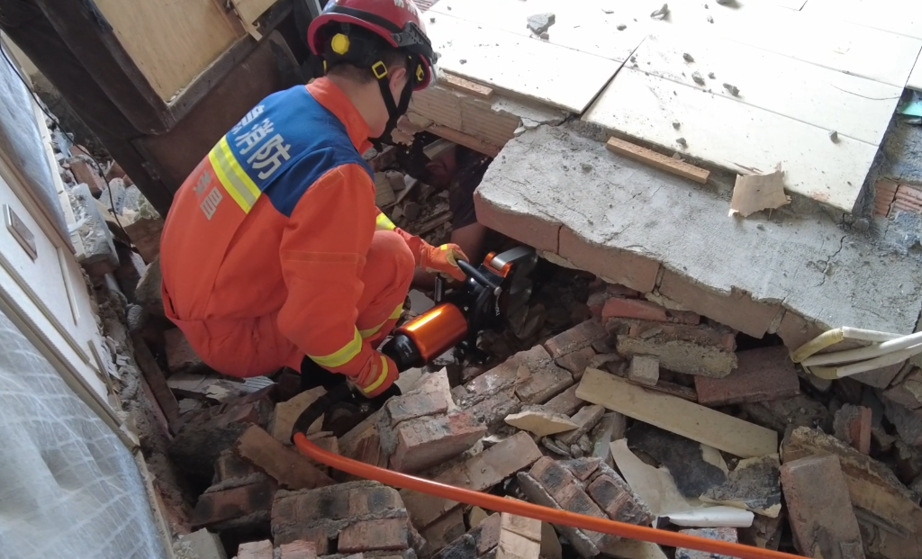 2消防员使用液压顶杆顶起倒塌的墙体。重庆荣昌消防供图
