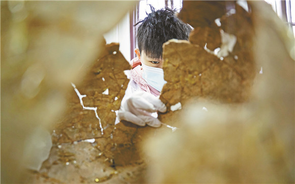陶器修复师赵鑫宇在为破碎的陶器进行拼对。王欢 摄