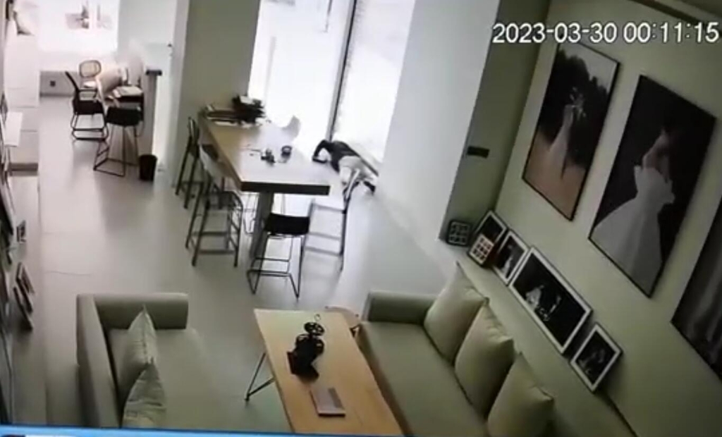 1男子从玻璃门与地面的缝隙钻进店内。重庆江北警方供图