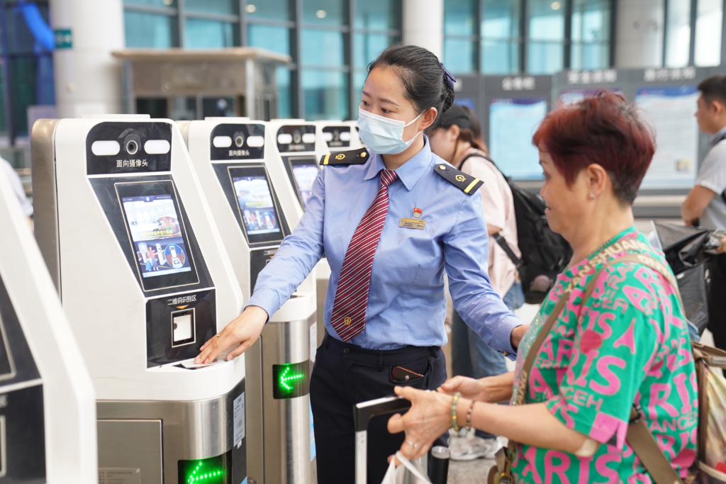 Staff members are helping passengers with ticket purchases. (Photographed by Wang Liang)