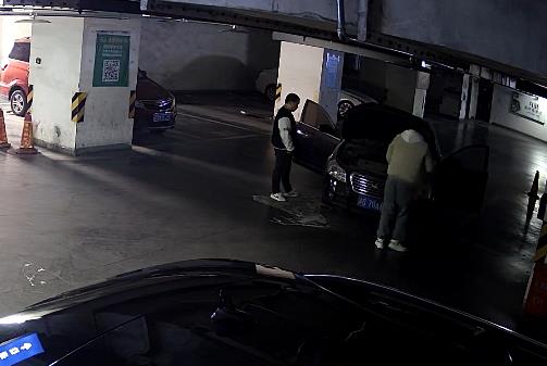 2陈某、李某在轿车前商量。重庆江北警方供图