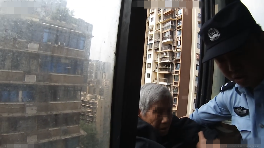 2民警与消防员等人合力将老人救回屋内。重庆沙坪坝警方供图