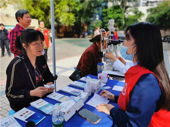志愿者在为居民做眼睛检查登记。九龙坡区西彭镇供图
