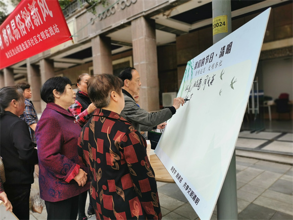 2居民在“清明追思·文明祭祀”展板上签字承诺。通讯员 胡琴 摄