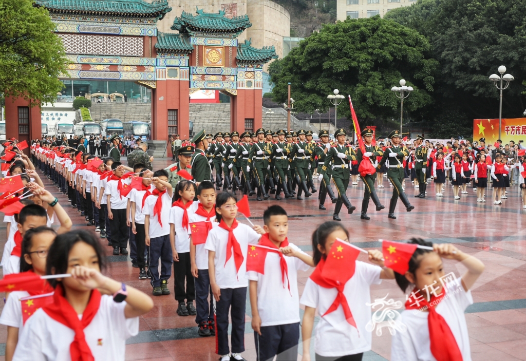 01，5月1日，重庆市人民广场，参加升旗仪式的小学生们迎接国旗。华龙网-新重庆客户端记者 张质 摄