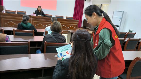 2志愿者向村民发放分类宣传资料并讲解分类知识。九龙坡区西彭镇供图