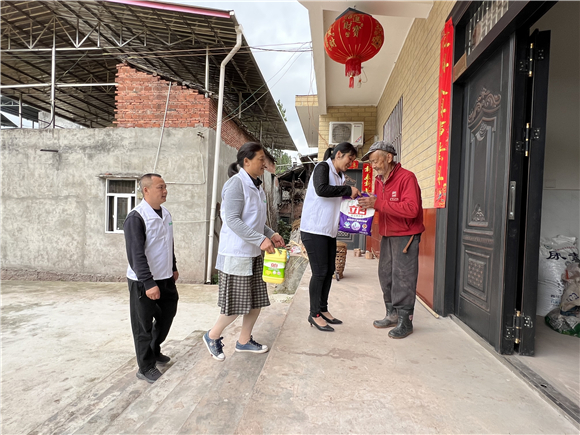 “和事佬”工作队队员为村里老人送生活用品。潼南区委宣传部供图 华龙网发