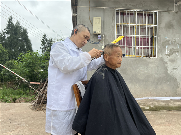 “和事佬”工作队队员为村里老人剪头发。潼南区委宣传部供图 华龙网发
