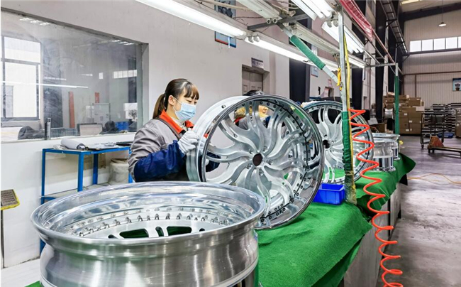 超群工业生产车间里，工人正在检查定制出口的轮毂（资料图片）。南川日报供图