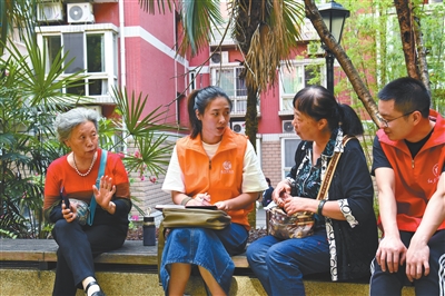 凤天路社区网格员雷欢（左二）在小区里收集群众诉求。记者 张浩 摄