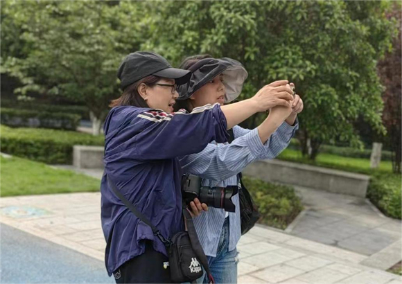 摄影师戴小霞指导志愿者拍摄。大竹林街道供图 华龙网发