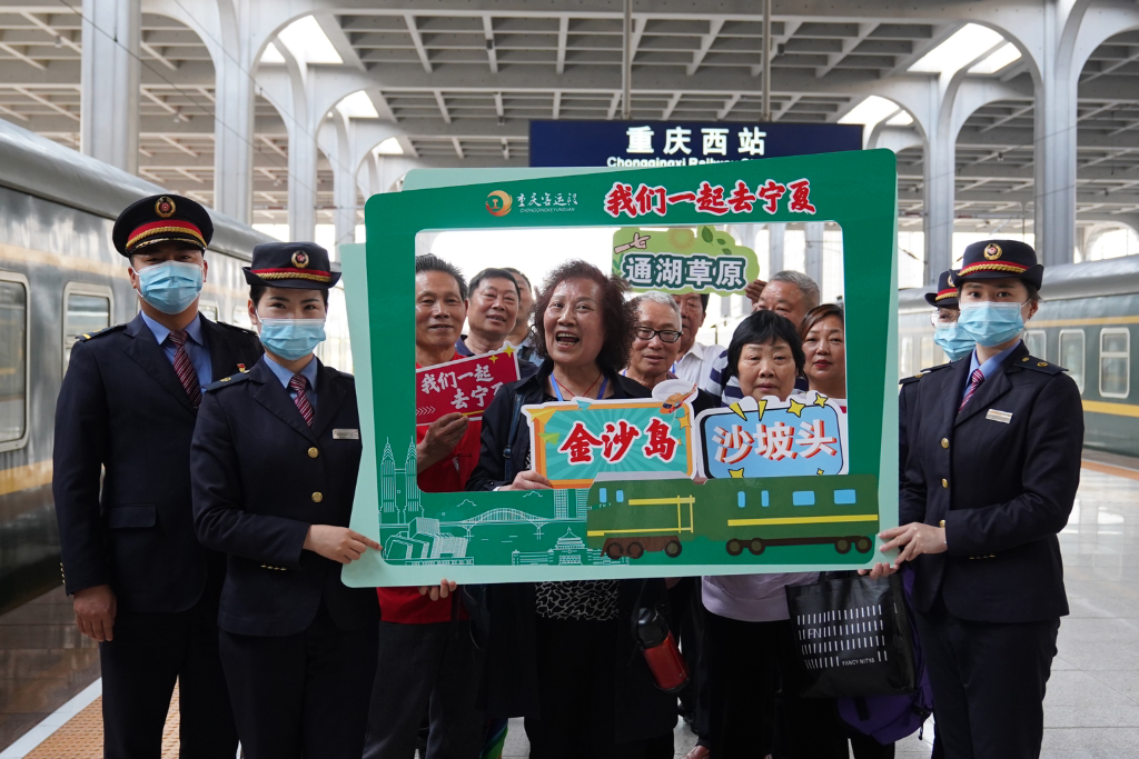 A group photo of tourists and train attendants. (Photographed by Li Wenhang)