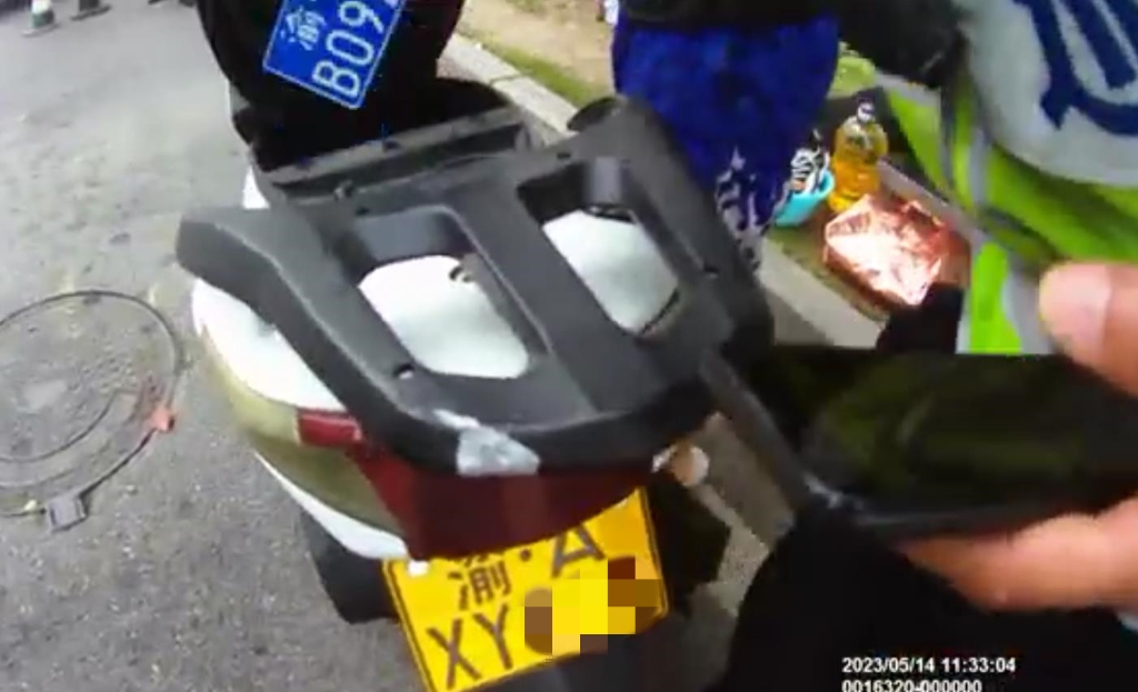 民警在摩托车坐垫箱内发现一个蓝色牌照，也是假牌照。重庆江北警方供图