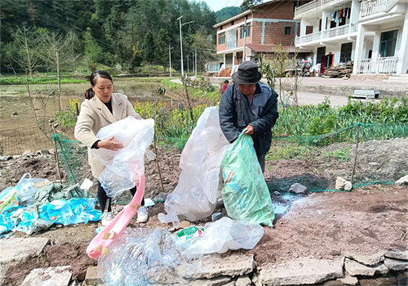 村民在回收废弃包装袋和农膜。通讯员 周亚琴 摄