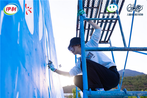 5伊利员工为白水台小学进行墙绘。伊利集团供图 华龙网发