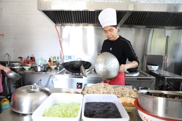 在云阳县故陵镇养老服务中心的厨房内，厨师正在精心地烹饪。云阳县民政局供图 华龙网发