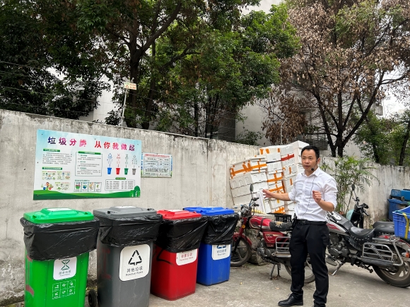 重庆市环境卫生事务中心指导员正针对垃圾桶放置问题进行现场指导。实习生 蒋灿 摄