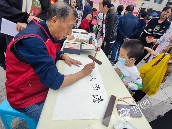 书法爱好者为居民挥墨书写。华龙网-新重庆客户端记者 闫仪 摄