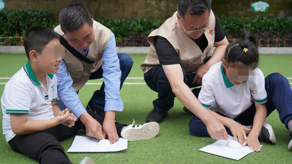 2军休干部代表与孩子们一起“挖盲盒”。重庆军休中心供图